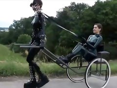 Latex freaks playing out kinky lesbian BDSM fantasy outdoors